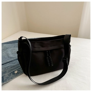 Close-up of black Oxford cloth tote bag with adjustable shoulder strap on fabric background