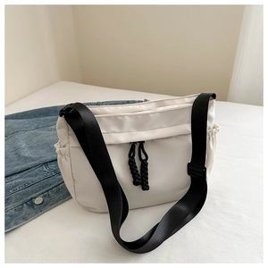 Detail view of large white oxford tote bag with black straps and side utility pocket