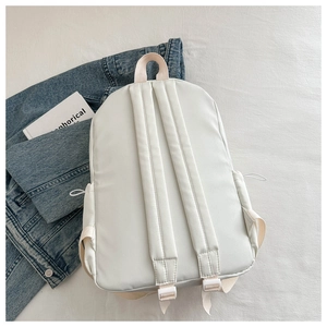Detail view of adjustable drawstrings and cushioned shoulder straps on an oxford backpack