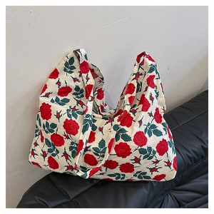 Close-up of red rose floral pattern on large canvas tote bag placed on leather sofa