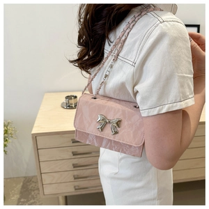 Detail of pink marble pattern crossbody bag with silver bow and leather chain strap