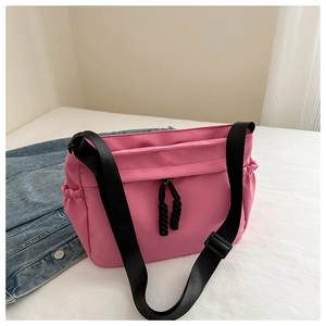 Detail of pink nylon tote bag with black drawstring and adjustable shoulder strap