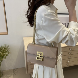 Retro apricot chain crossbody bag with golden geometric lock shown on female model