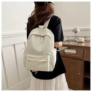 Detail view of the beige Oxford cloth backpack featuring a stylish side fashion label