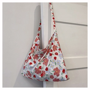 Close-up of cream floral tote bag with red and blue hand-painted flower patterns