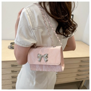 Detail of light pink PU bag with silver butterfly buckle and leather chain strap