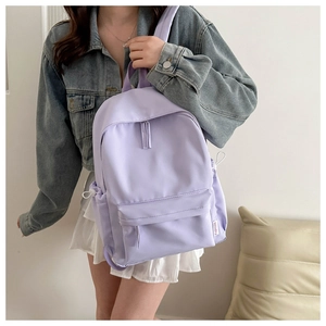 Detail view of the lilac purple waterproof nylon fabric and front zipper pocket with fashion label