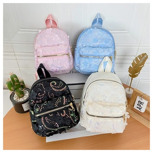 Detailaufnahme kleiner Pailletten-Rucksäcke mit Blumenstickerei in Rosa, Blau, Schwarz und Weiß