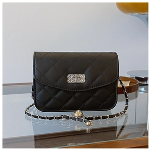 Detail of black quilted leather crossbody bag with metal twist lock and chain strap