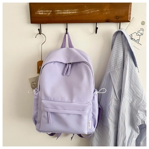 Detail of lavender oxford backpack showing waterproof fabric and front zip pocket