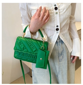 Detail of green quilted crossbody bag with FASHION embossing and matching small pouch