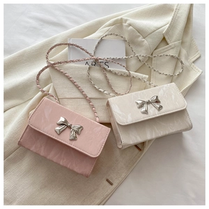 Detail of pink and marble beige crossbody bags with silver butterfly clasps and chain straps