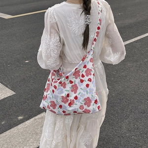 Floral canvas tote bag with large capacity shown on model in a summer outdoor setting