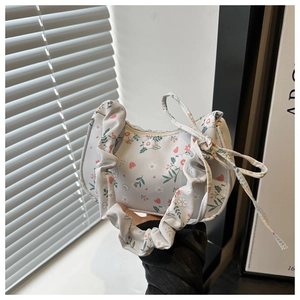 Detail of floral canvas tote bag featuring pleated strap and decorative bow detail
