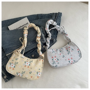 Detail of floral underarm bags with scrunchie handles in yellow and blue colors