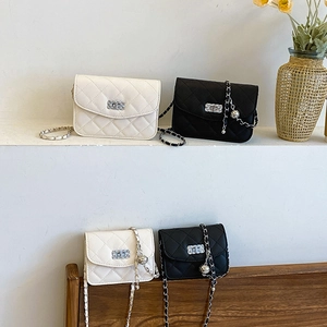 Quilted crossbody flap bag with chain strap and gold bead charm in black and white