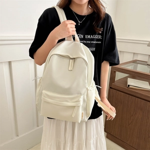 Minimalist cream white Oxford cloth backpack with large capacity shown in a lifestyle setting
