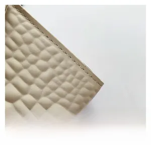 Détail de cuir beige à motif crocodile avec des coutures soignées sur le sac