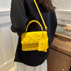 Quilted yellow crossbody bag with FASHION embossment, woven handle and mini pouch