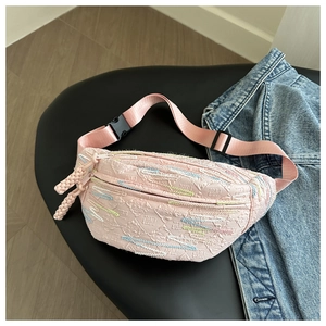 Pink dumpling waist bag with textured embroidery and adjustable nylon strap on denim