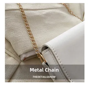 Close-up of white leather saddle bag showing gold chain strap and detailed stitching