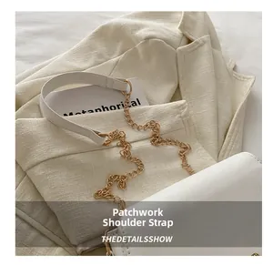 Detail view of the elegant white leather strap combined with a gold metal chain