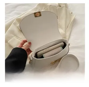 White saddle bag interior view showing capacity for a phone and small knit wallet