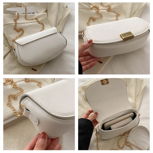 Detail view of white leather crossbody bag with gold chain strap and interior storage