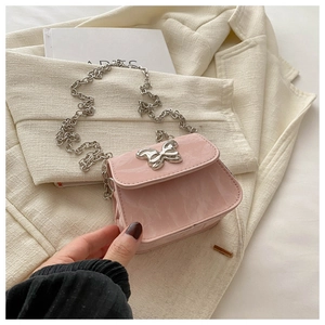 Détail du mini sac en cuir verni rose clair avec fermoir papillon et chaîne argentée