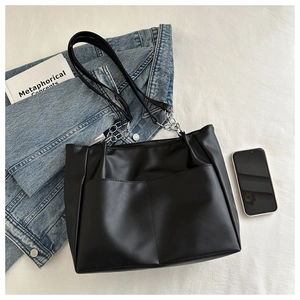 Dettaglio della borsa tote in pelle PU nera con catena argentata e tracolla alla moda