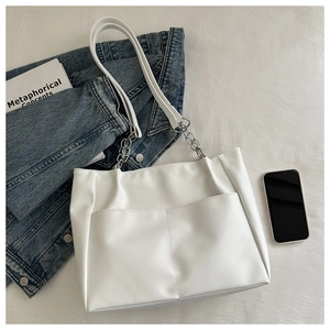 Dettaglio borsa tote bianca in pelle PU con tracolla a catena d'argento e tasche frontali