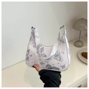Close-up of white butterfly star pattern handbag held in a minimalist aesthetic setting