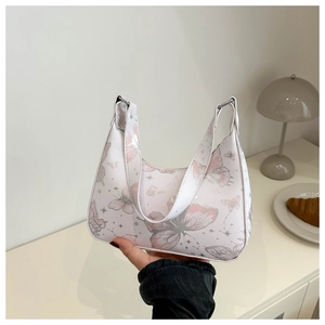 Close-up of white leather shoulder bag featuring pink butterflies and grey star patterns