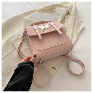 Detail of pink matte texture bag with elegant silver butterfly metal buckle and studs
