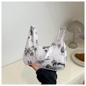 Detail of white underarm bag featuring elegant black butterfly print and fine stitching