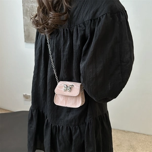 Sac bandoulière rose texture marbre avec boucle papillon et bandoulière chaîne