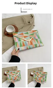 Detail of color-block envelope clutch with geometric print and V-shaped gold metal trim