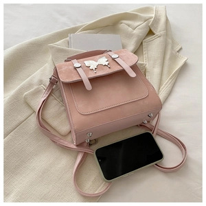 Detail of pink faux suede handbag with silver butterfly clasp and versatile straps