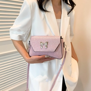 Rosa glitzernde Umhängetasche mit silberner Schmetterlingsschnalle auf weißem Outfit