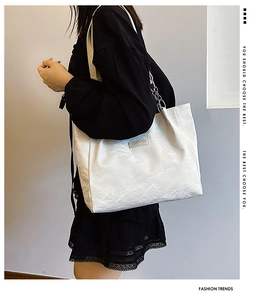 Détail du sac cabas blanc avec texture plissée, bandoulière en cuir et chaîne argentée