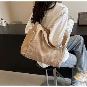 Detailed side view of khaki nylon crossbody bag with wide strap and side pockets