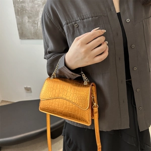 Golden crocodile pattern shoulder bag with metallic finish and elegant chain strap
