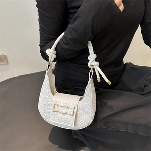 White crocodile-embossed half-moon underarm bag with gold buckle and twisted rope handle