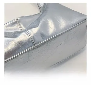 Detail of silver metallic crinkled leather shoulder bag with reinforced double stitching