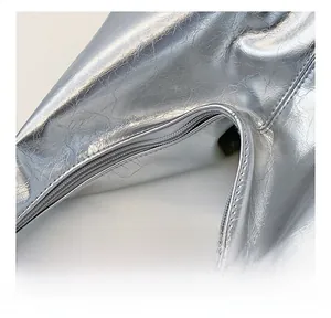 Detail showing smooth zipper closure and shiny metallic silver pleated fabric texture