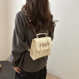 Elegant cream leather mini backpack with a vintage gold butterfly clasp for women