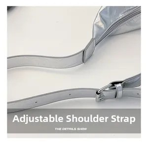 Macro shot of an adjustable shoulder strap on a metallic silver crossbody tote bag