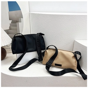 Detail of minimalist nylon crossbody bags with Forever Young straps in black and beige