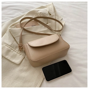 Minimalist beige crossbody bag shown with a smartphone to demonstrate daily capacity