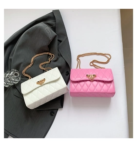 Detailed view of white and pink quilted flap bags with golden metal chain straps